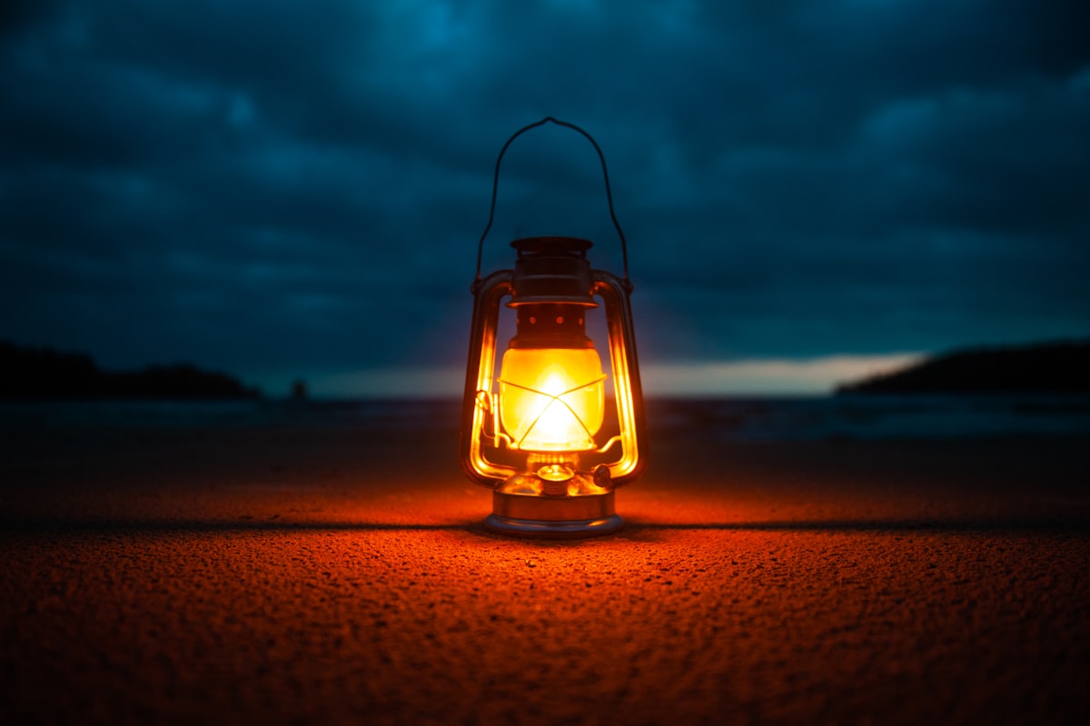 Glowing camping lantern at a campsite at night